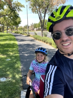 Piers on a bike with his daughter